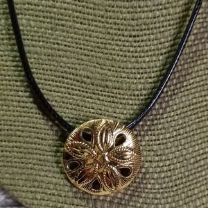 Goldtone sand dollar on black cord necklace